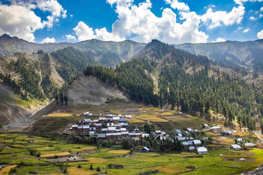 Panoramic view of Gurez village in Kashmir, surrounded by lush mountains and fields.